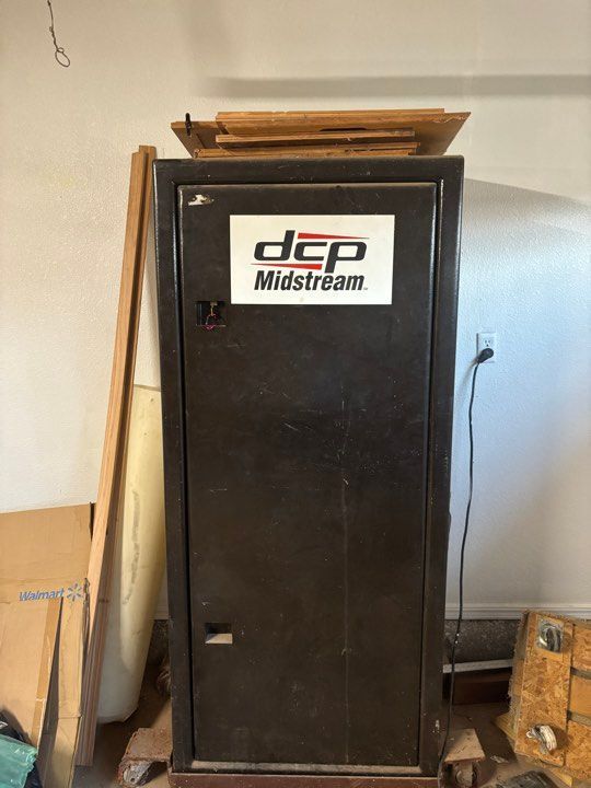 Dark metal gun safe with DCP Midstream logo, inside a room
