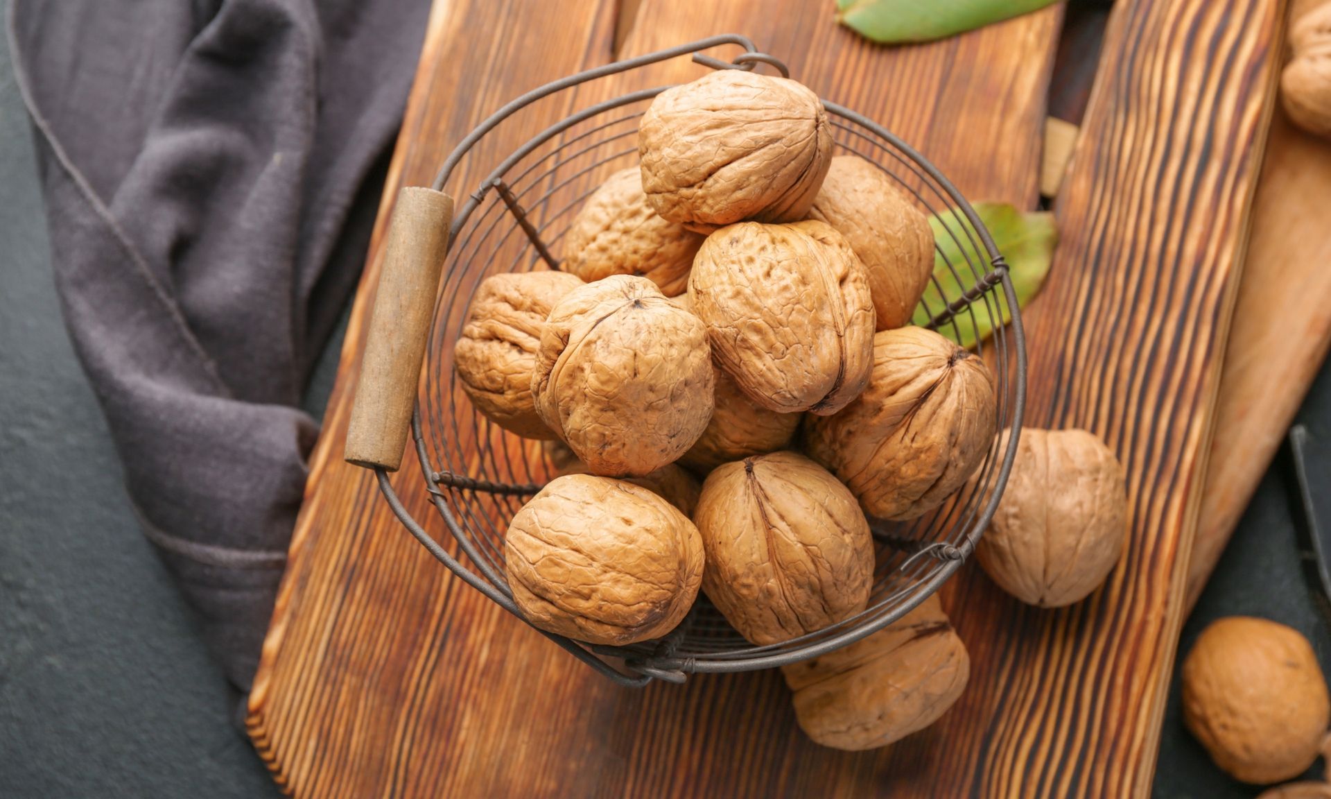 Een mand gevuld met walnoten op een houten snijplank.