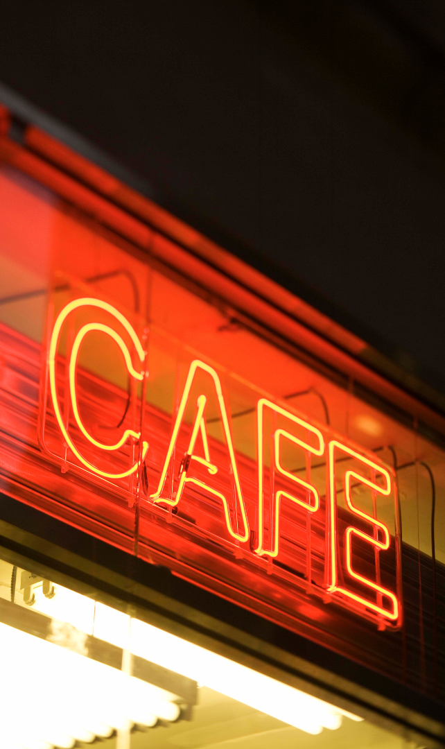 A red neon sign that says cafe on it