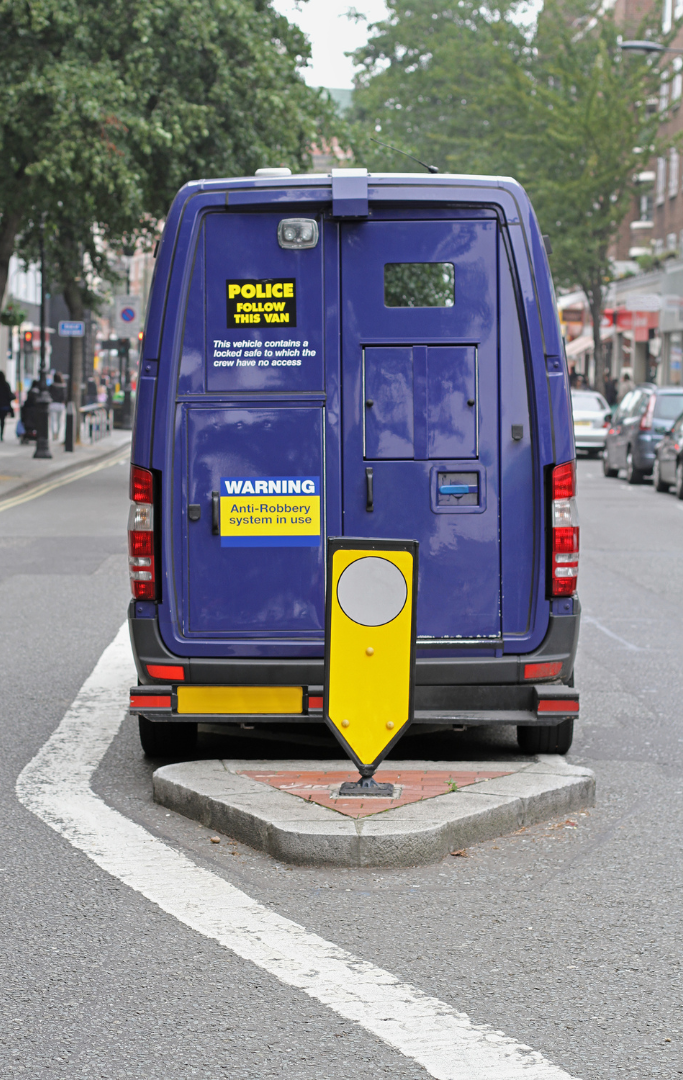 A blue police van is parked on the side of the road