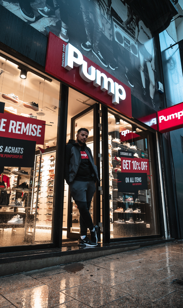 A man is standing in front of a pump store.