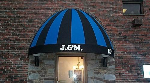A blue and black awning over the entrance of a brick building