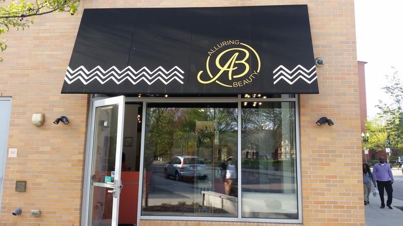 A brick building with a black awning that says jb on it