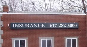 A brick building with a sign that says insurance on it