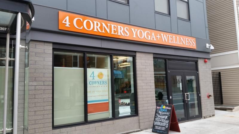 A building with a sign that says 4 corners yoga wellness