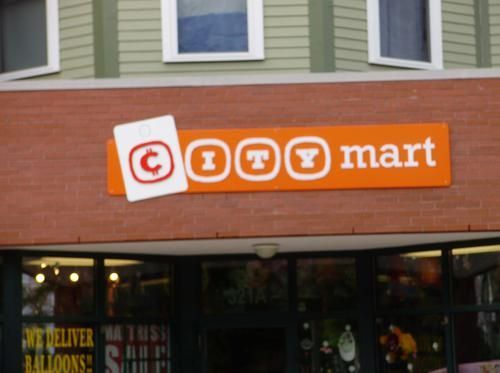 A store front with an orange sign that says toy mart