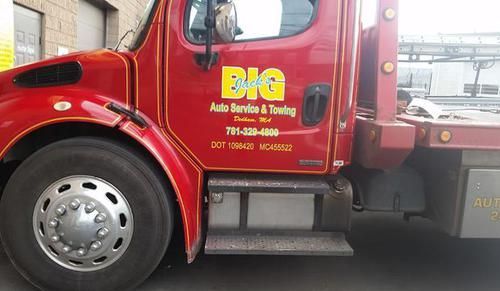 A red tow truck is parked in front of a building.