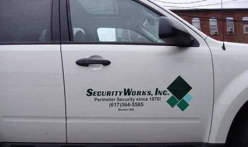 A white car with security works inc. written on the side