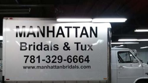 A manhattan bridals and tux truck is parked in a garage