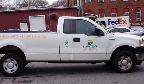 A white truck is parked in front of a fedex truck