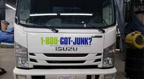 A white truck with the words 1-800 got junk on it