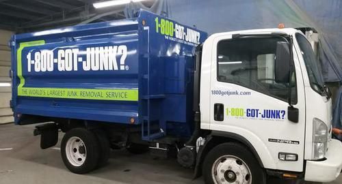 A blue and white garbage truck that says 1-800-got-junk