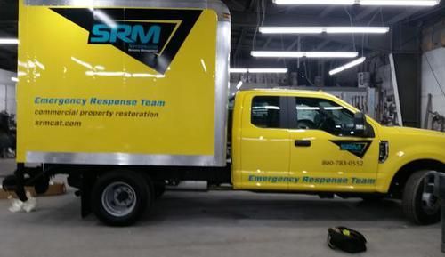 A yellow srm truck is parked in a garage