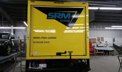 A yellow srm truck is parked in a garage