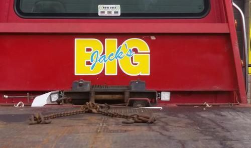 The back of a red tow truck with the word big on it.