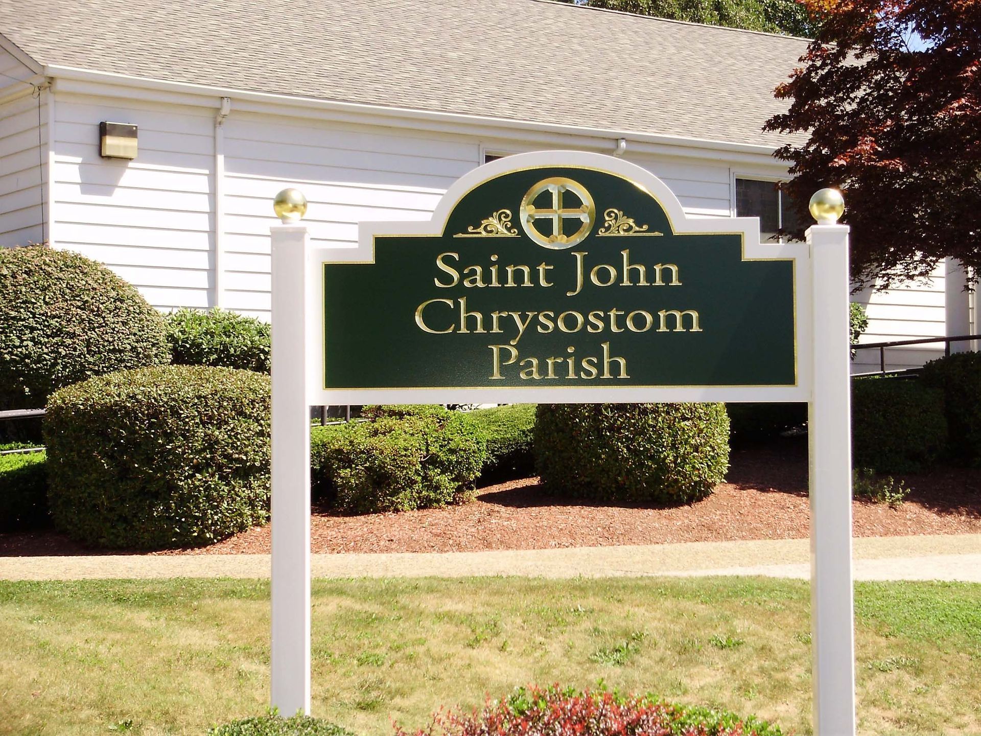 A green sign that says saint john chrysostom parish
