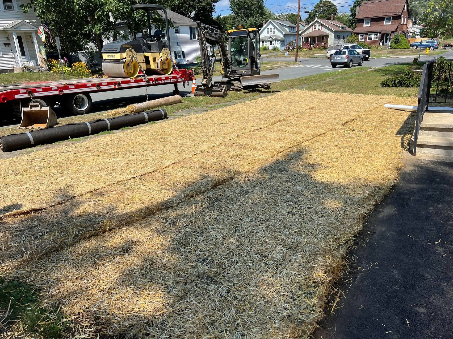 Construction site. Roadway with gravel base; heavy machinery and trailer in the background.