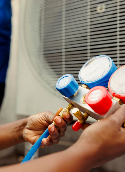 Manos conectando medidores a una unidad de aire acondicionado.