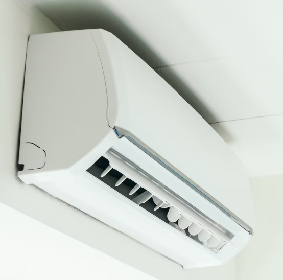 Unidad de aire acondicionado de pared de color blanco sobre una pared blanca.