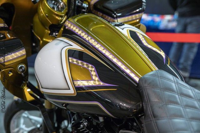 Een close-up van een motorfiets met een paarse en gouden lak. met bladgoud en pinstriping