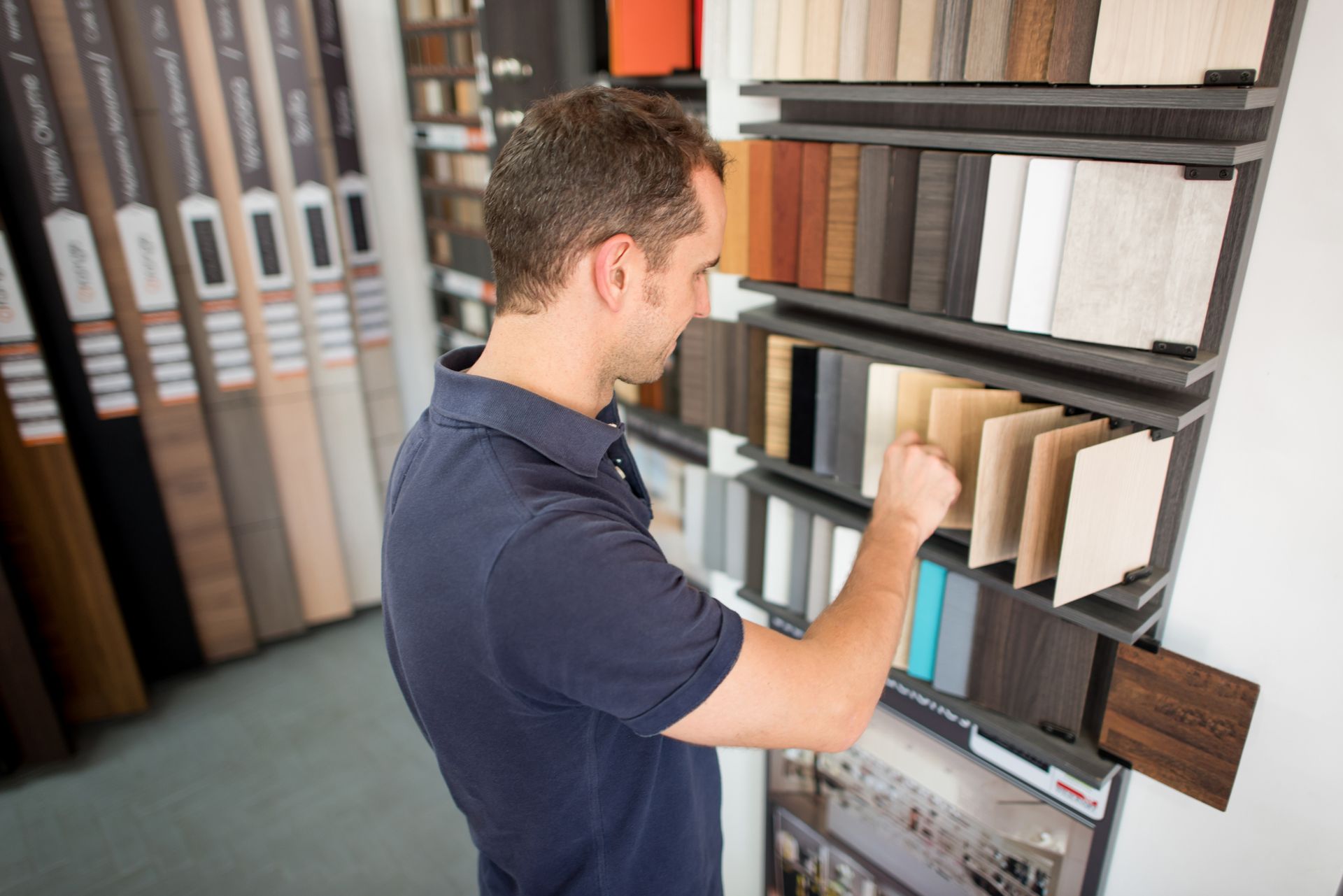 A man is looking at samples of wood in a store.