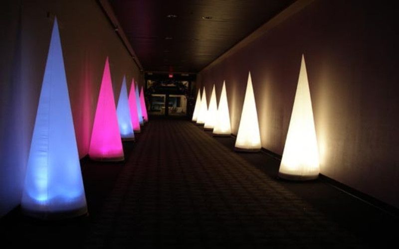 A hallway with a row of cones lit up in different colors