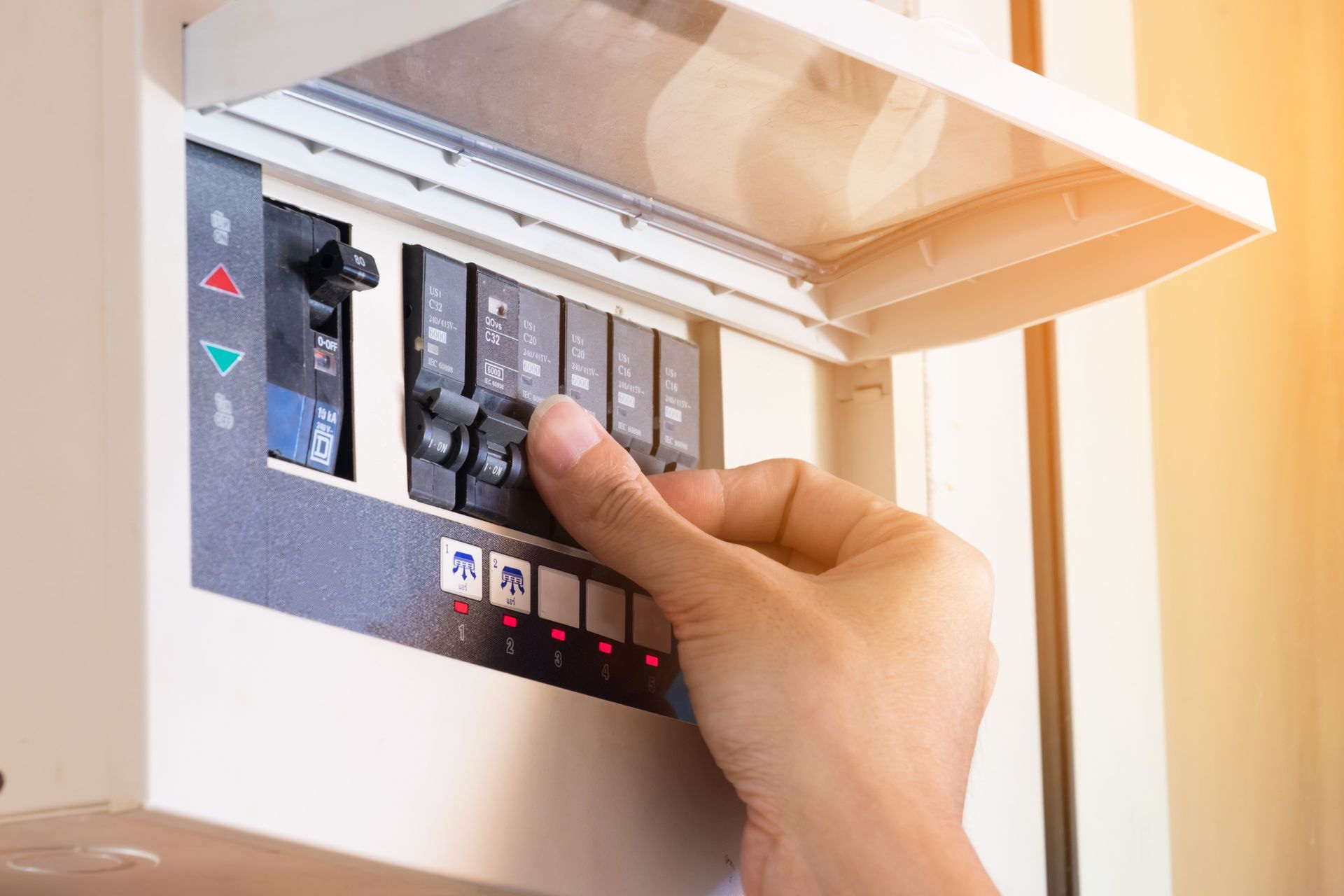 A person is turning a switch on a electrical box.