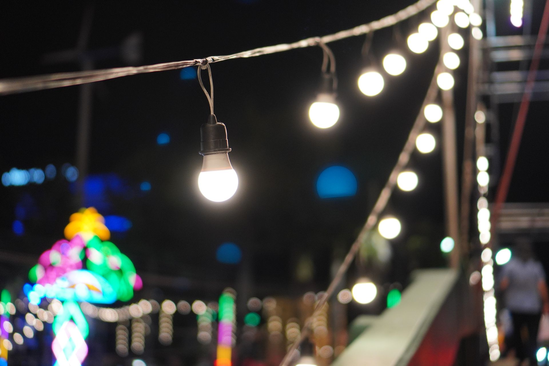 A bunch of lights hanging from a wire at night
