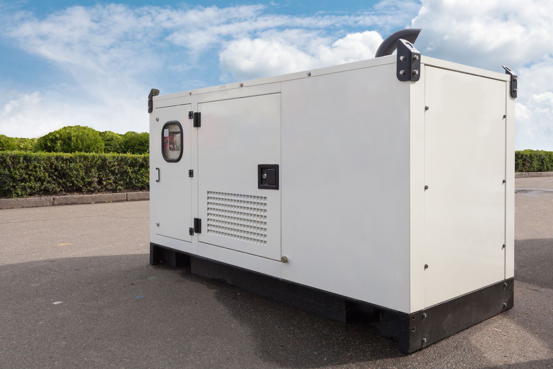 A white generator is parked on the side of the road.