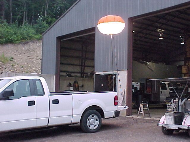 A white truck is parked in front of a garage