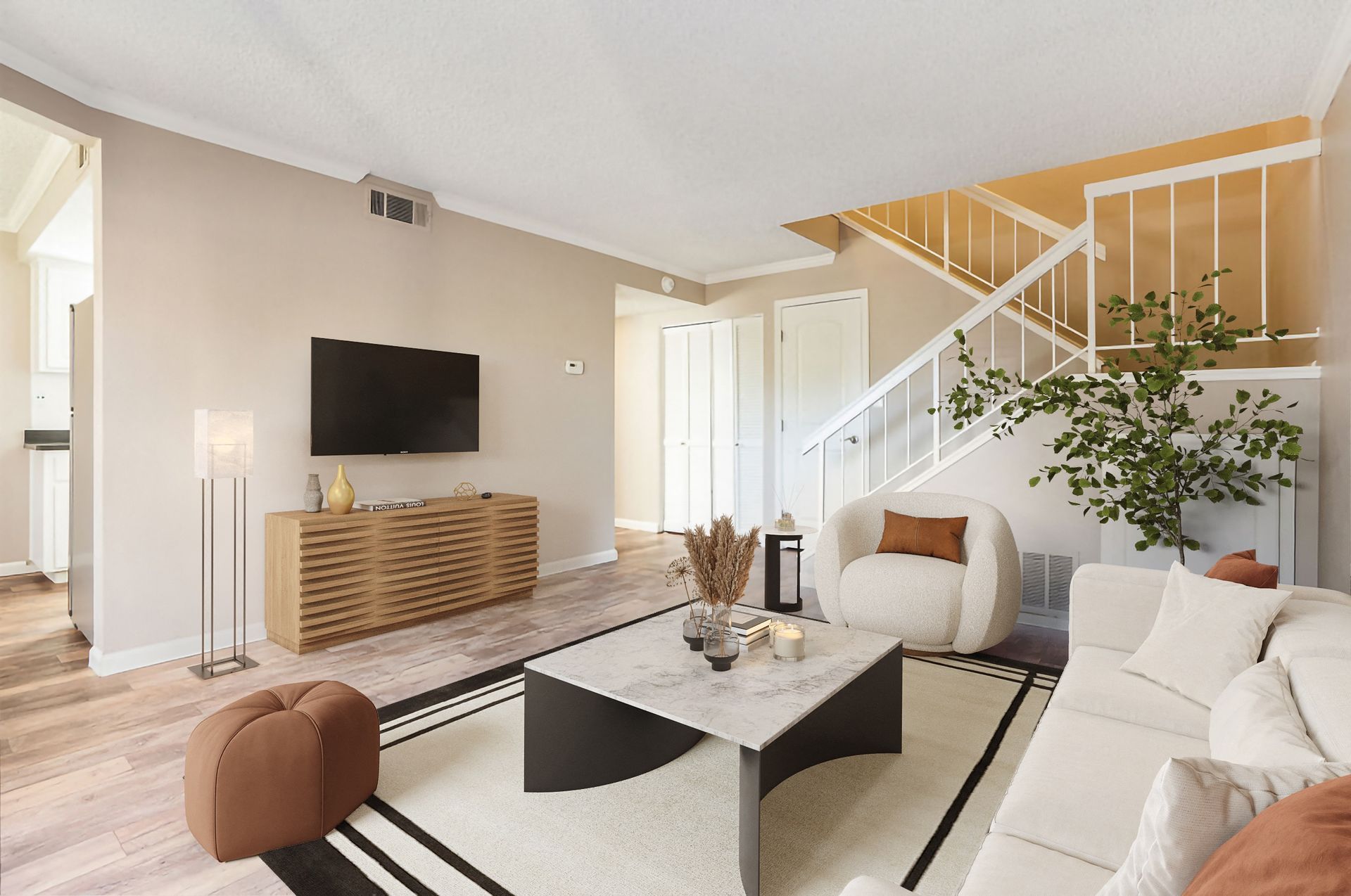 Bright apartment living room with TV, console, sofa, and staircase.