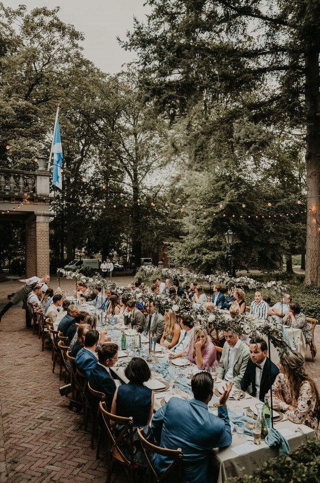 Een bruid en bruidegom lopen voor een groot gebouw.