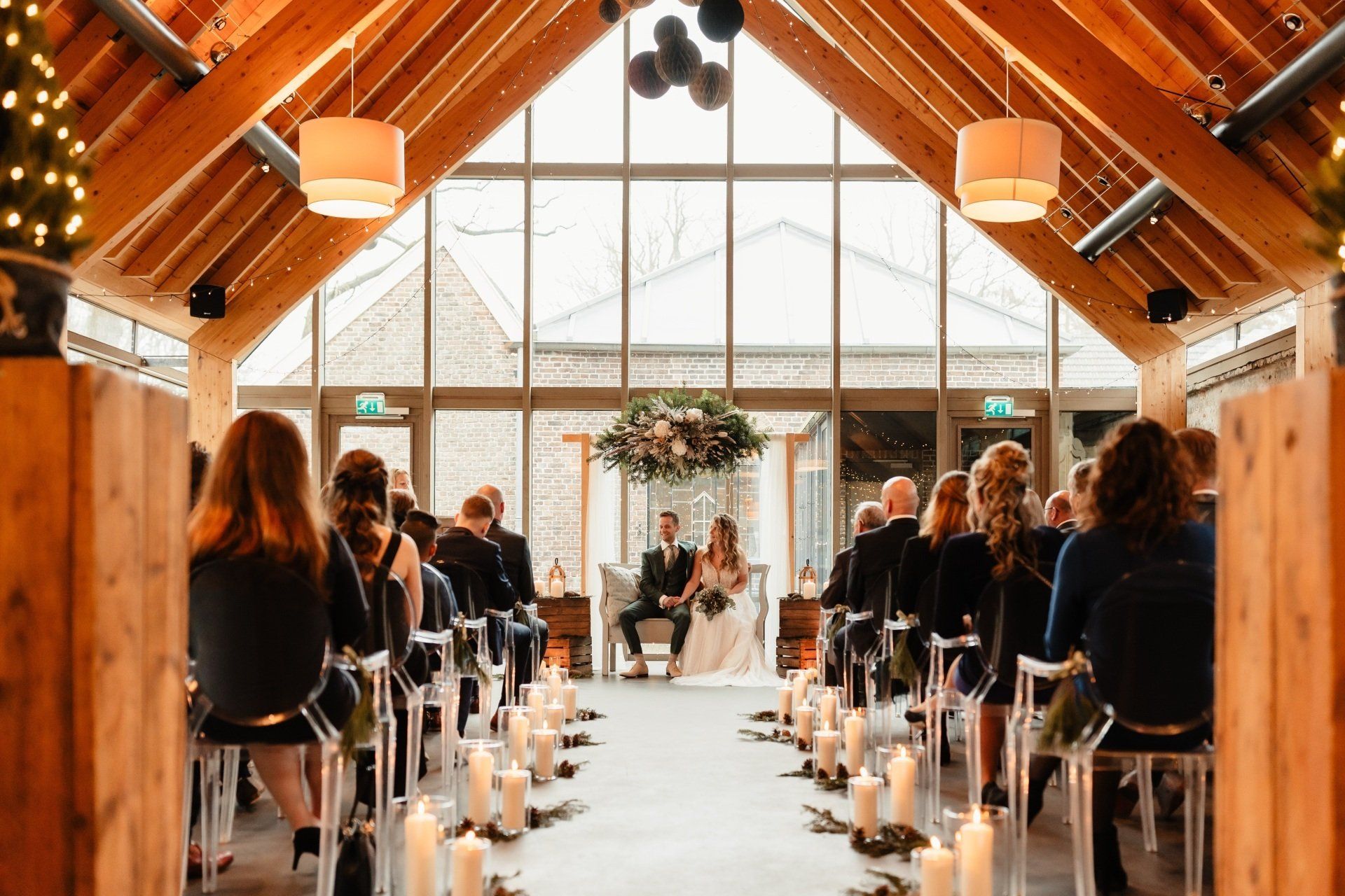 Een bruid en bruidegom trouwen in een grote kamer met kaarsen.