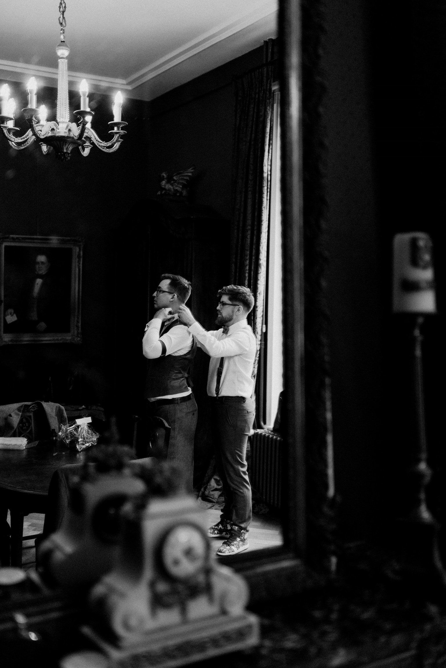 Een zwart-witfoto van twee mannen die zich klaarmaken voor een bruiloft.