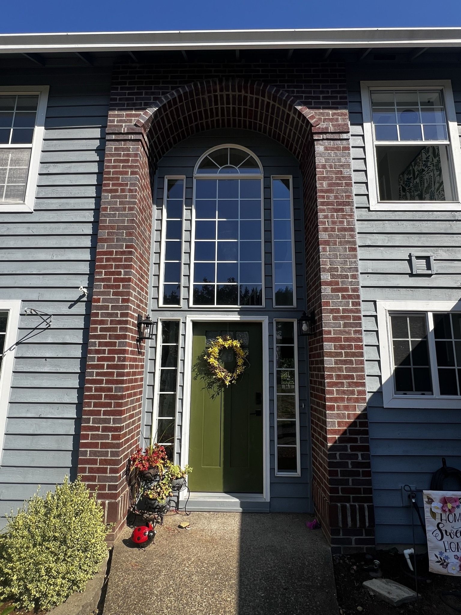 A blue house with a green door and a brick archway