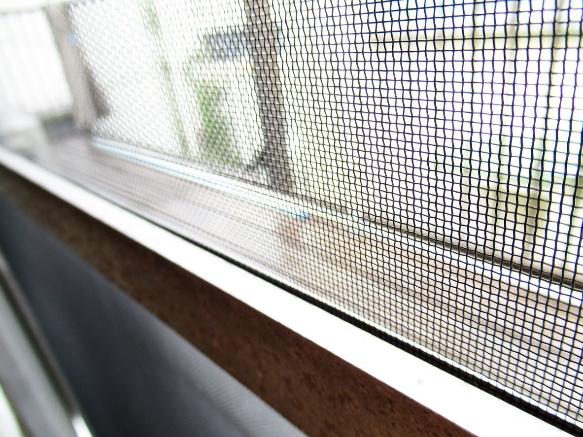 A close up of a mosquito screen on a window