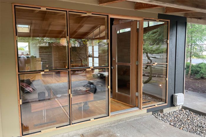 A house with a lot of windows and sliding glass doors.