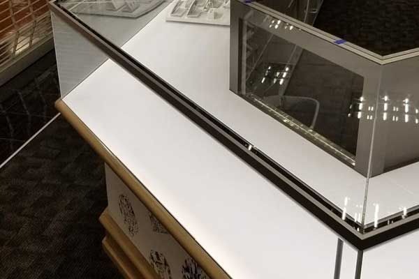 A glass display case with a mirror on top of it