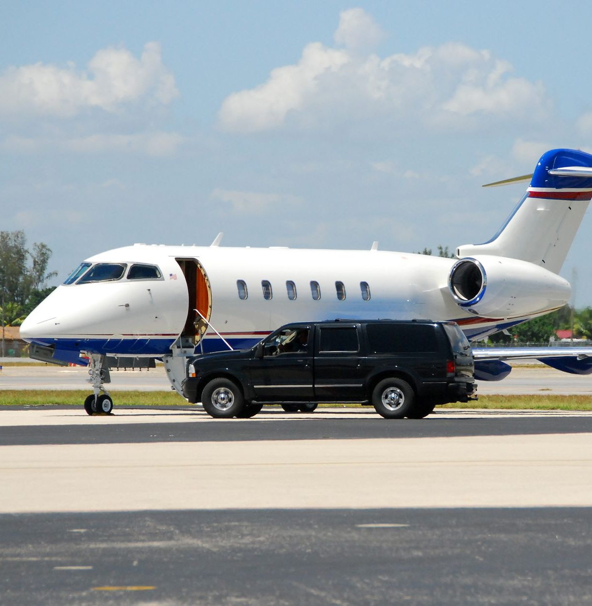 Pilot and flight attendant at airplane, pilot carrying a briefcase, boarding stairs.