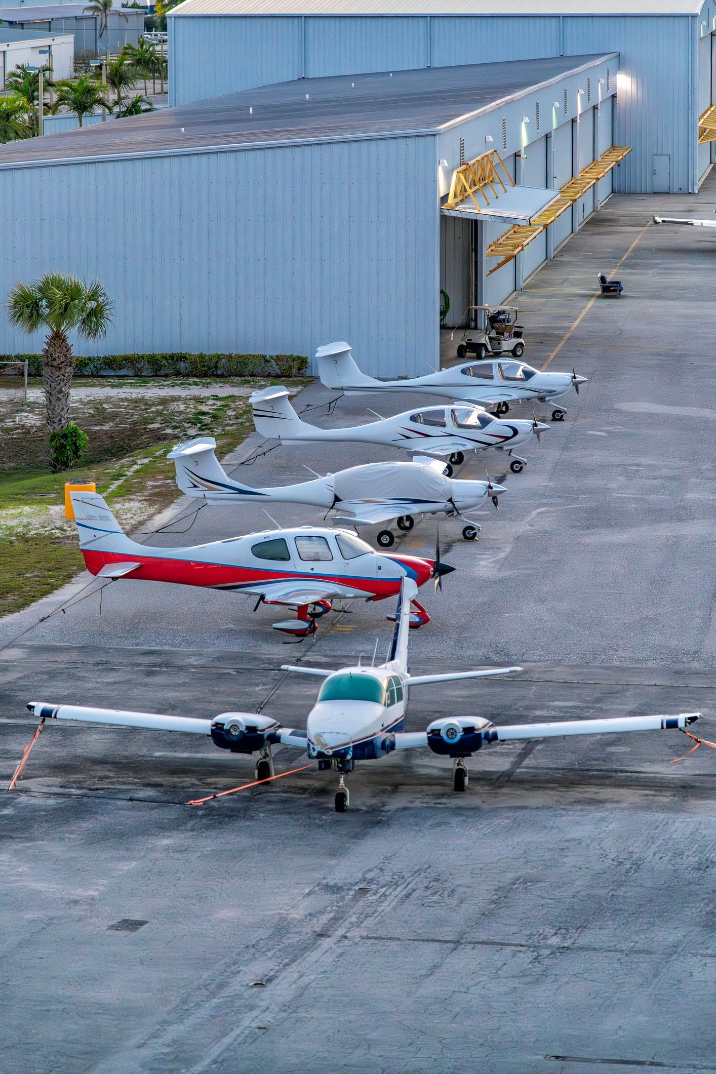 Mechanics working on an aircraft engine inside a hangar.