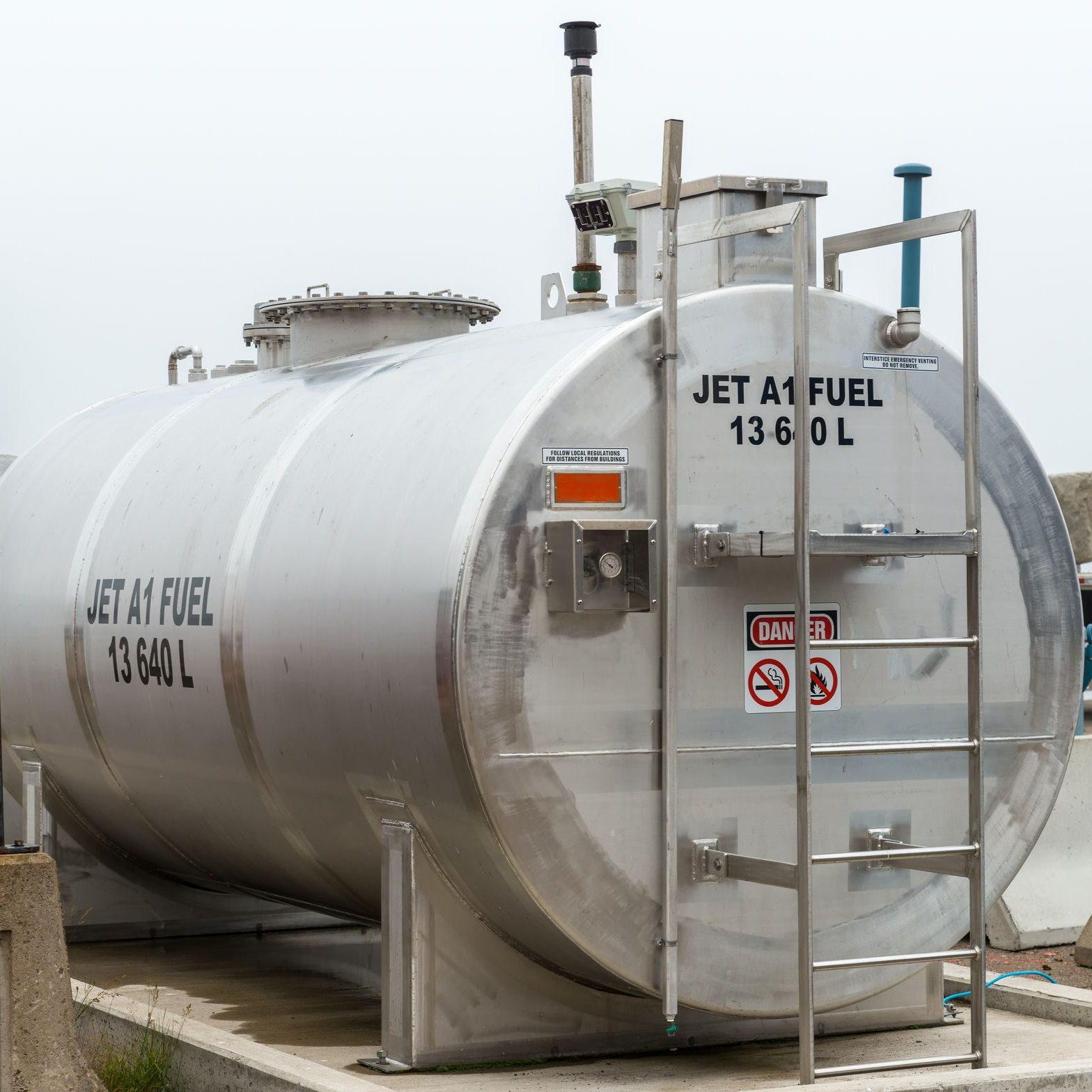 Aircraft being de-iced with a truck-mounted boom arm, on a snowy airfield.
