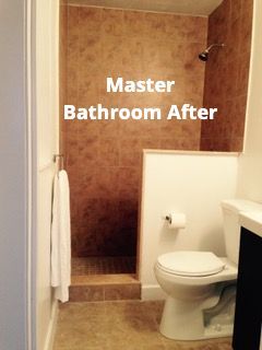 A renovated master bathroom featuring a tiled walk-in shower next to a white toilet.