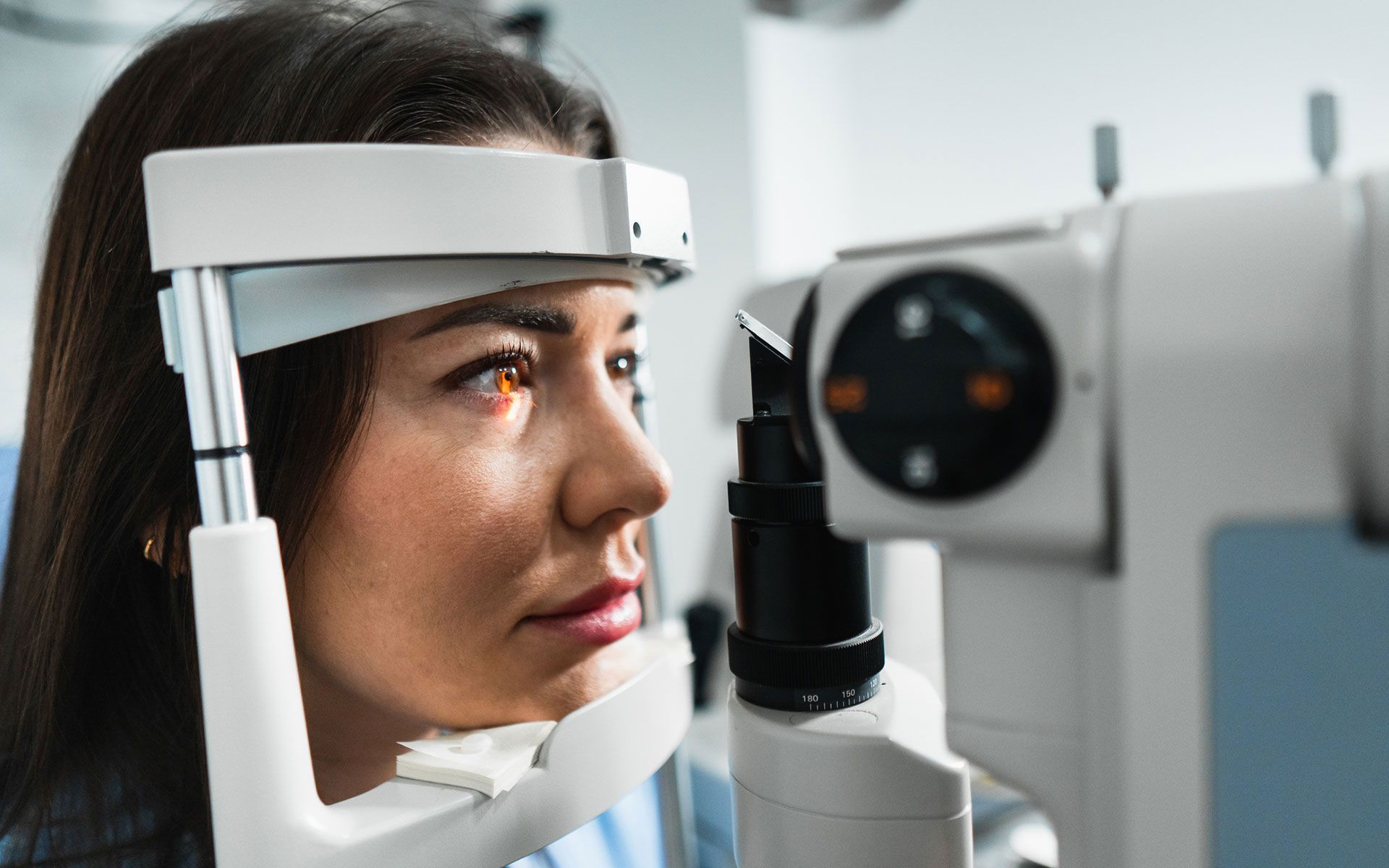 Woman undergoing an eye exam with a slit lamp.