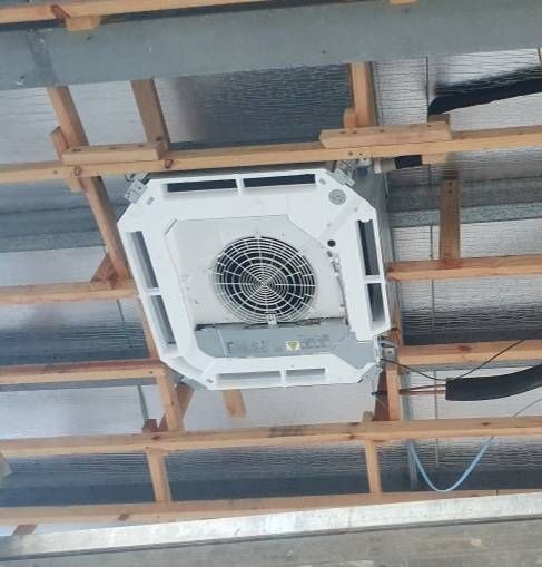 Ceiling-mounted air conditioning unit installed on wooden supports in a building under construction.— Cool Tropics Air Conditioning & Refrigeration in Mourilyan Harbour, QLD