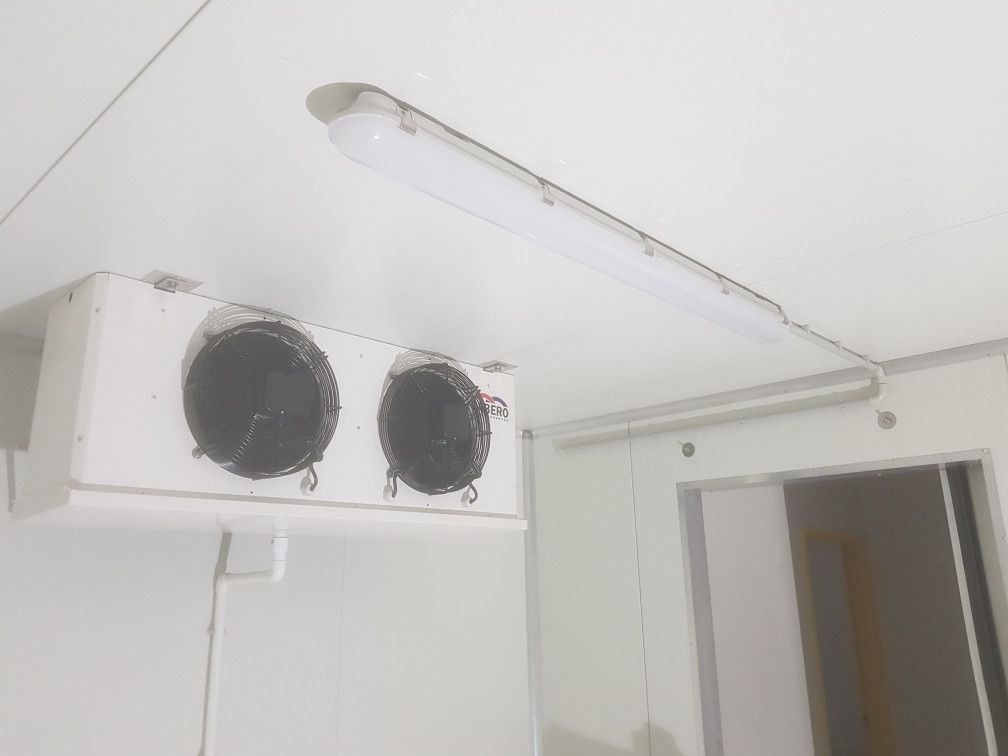 White refrigerator unit with two fans and a fluorescent light on a white ceiling.— Cool Tropics Air Conditioning & Refrigeration in Mourilyan Harbour, QLD