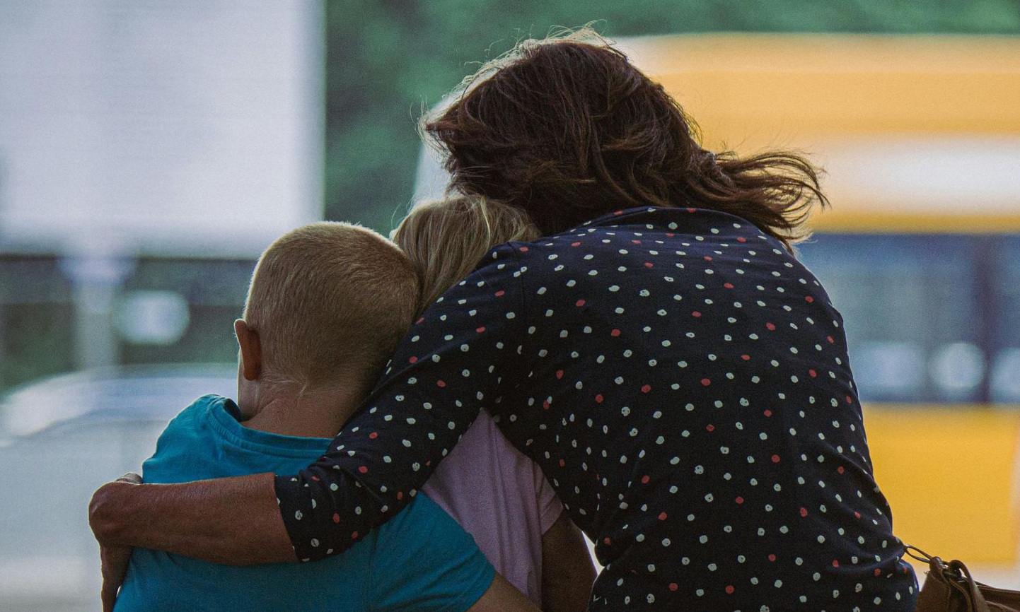 Woman hugging two children