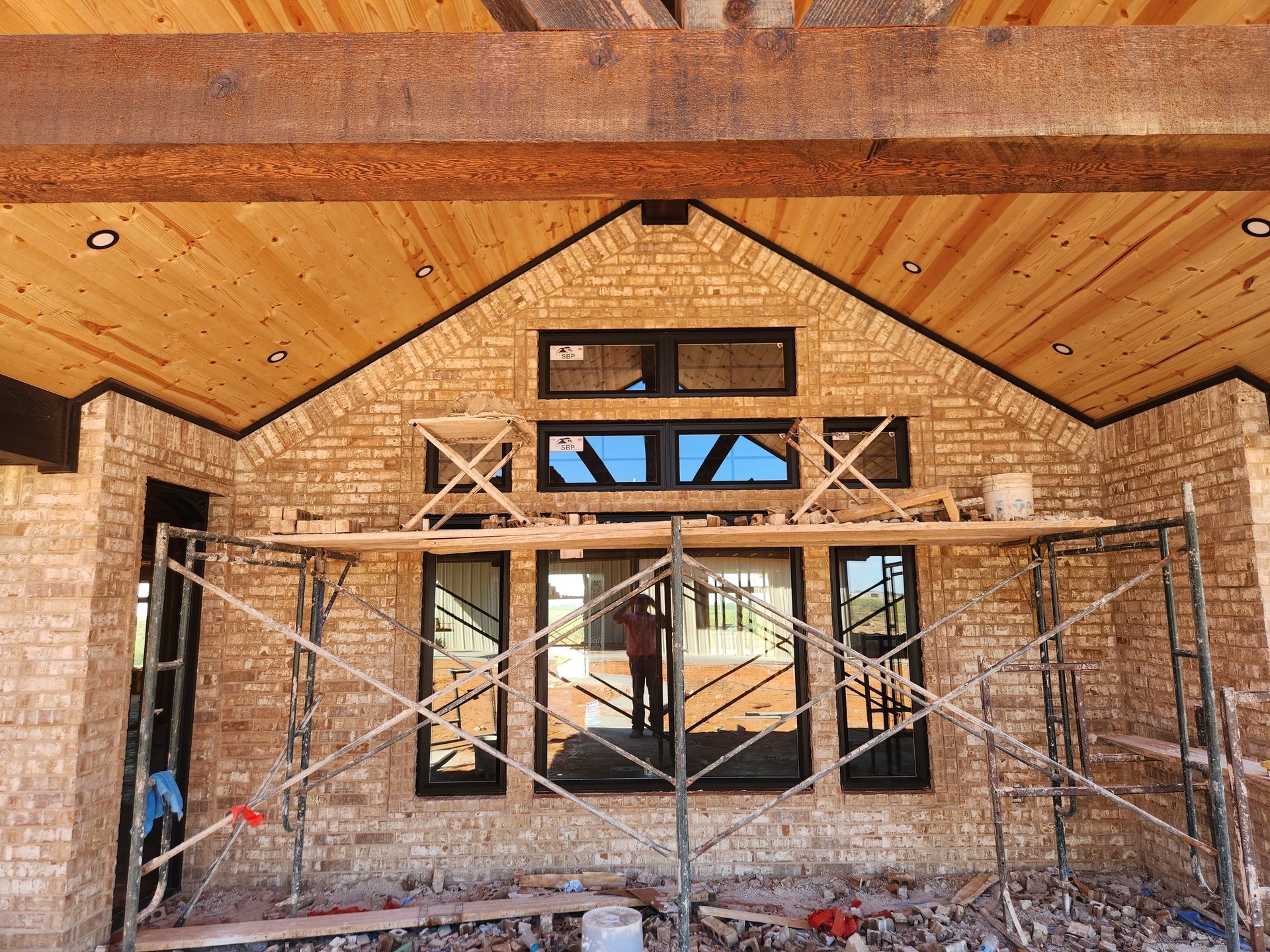 A brick building with a wooden ceiling and scaffolding in front of it.