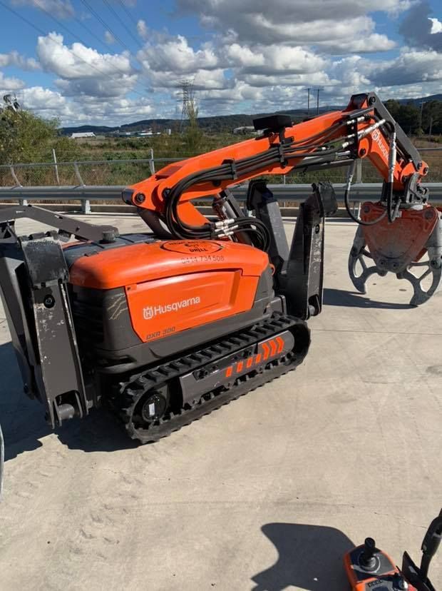 A Robotic Excavator Is Parked On The Side Of The Road — Newcastle Cut N Drill Pty Ltd In Boolaroo, NSW