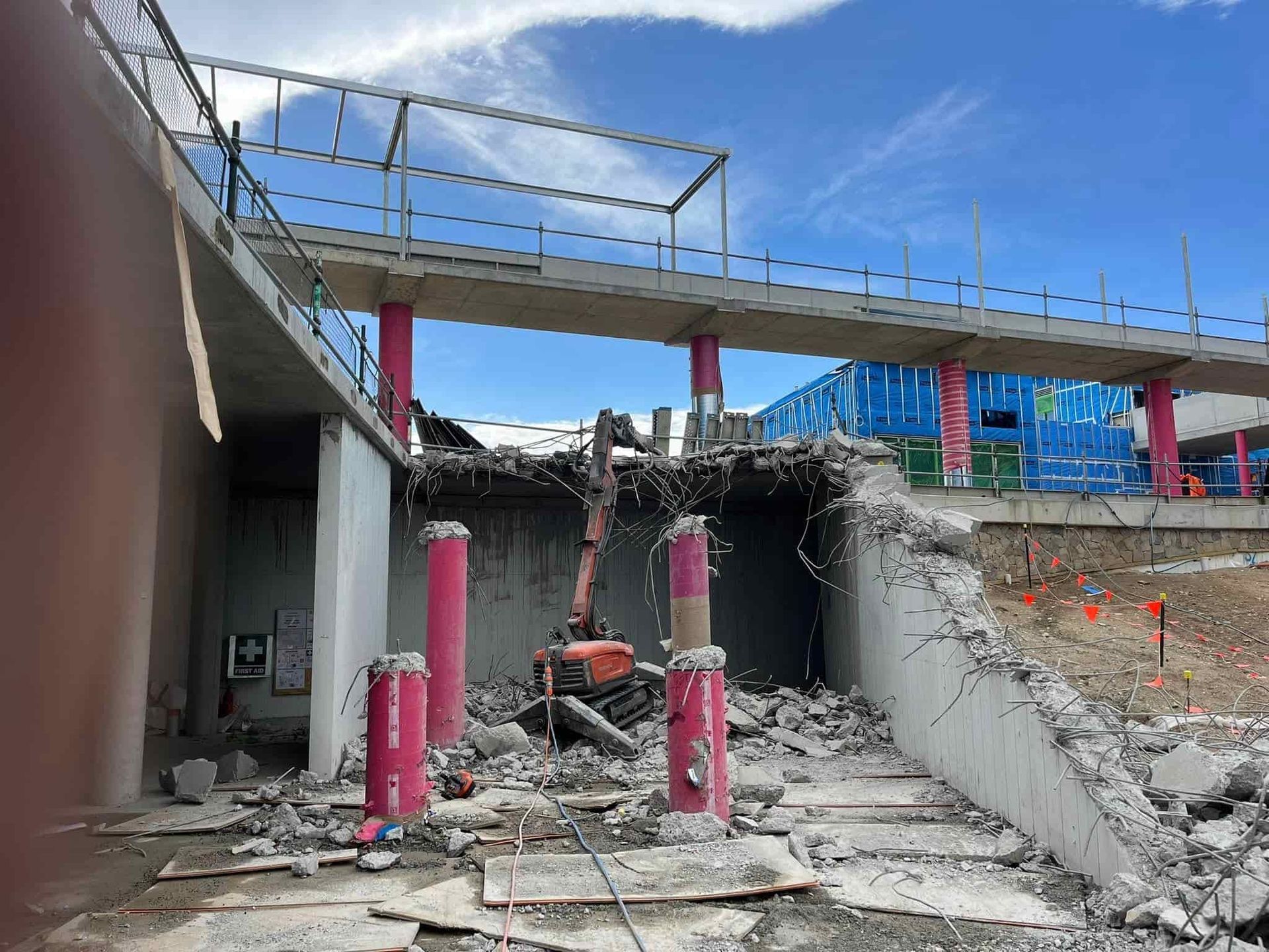 A building is being demolished with a bridge in the background. — Newcastle Cut N Drill Pty Ltd In Boolaroo, NSW