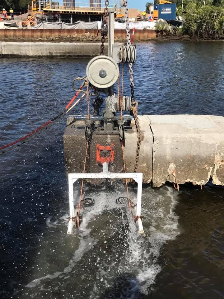 A machine is cutting a concrete pipe in the water. — Newcastle Cut N Drill Pty Ltd In Boolaroo, NSW